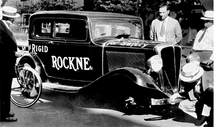Herb (lower right) demonstrates the stability of the Rigid Rockne (even on three wheels!) to a skeptical customer outside Babbington Studebaker in the dispiriting days of 1933.
